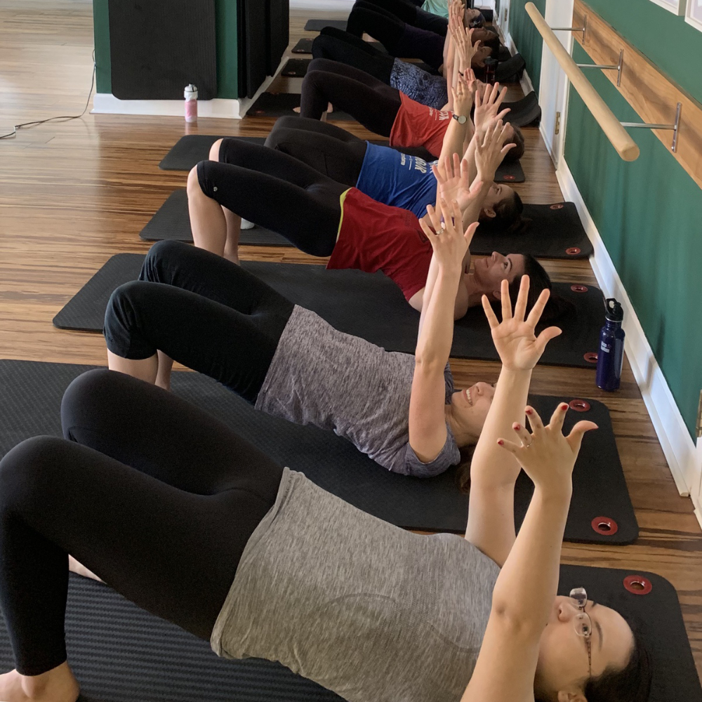 group of women in bridge position exercising glutes and hamstrings